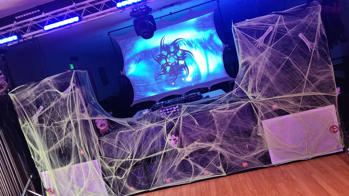 Halloween DJ booth with spider web decorations and lighting